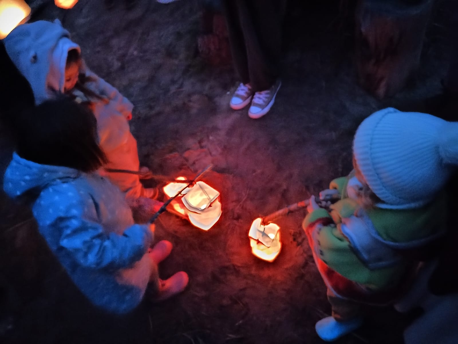 Crianças com lanternas numa celebração ao anoitecer